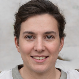 Joyful white young-adult female with short  brown hair and grey eyes