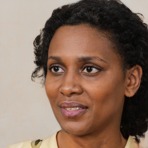 Joyful black young-adult female with medium  brown hair and brown eyes