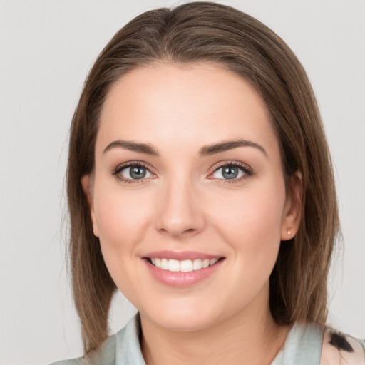 Joyful white young-adult female with medium  brown hair and grey eyes