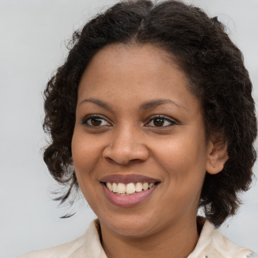 Joyful black young-adult female with medium  brown hair and brown eyes