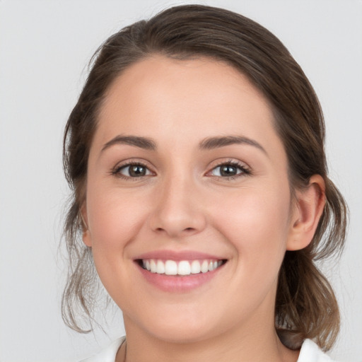 Joyful white young-adult female with medium  brown hair and grey eyes