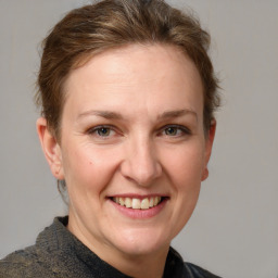 Joyful white adult female with medium  brown hair and grey eyes