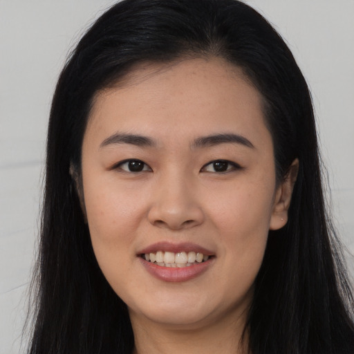 Joyful asian young-adult female with long  black hair and brown eyes