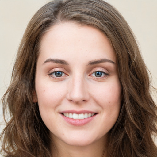 Joyful white young-adult female with long  brown hair and green eyes