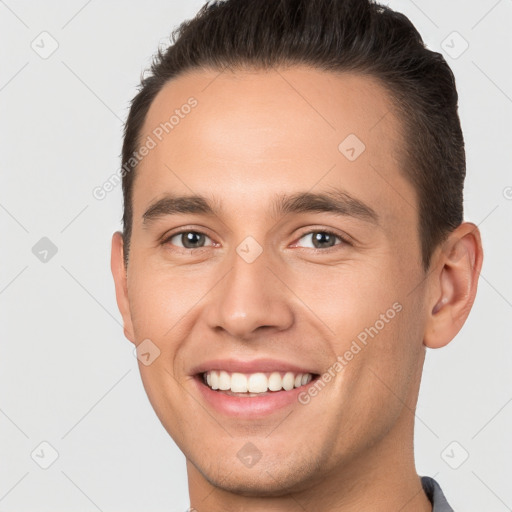 Joyful white young-adult male with short  brown hair and brown eyes