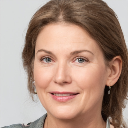 Joyful white adult female with medium  brown hair and grey eyes