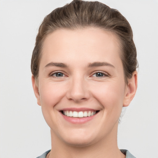 Joyful white young-adult female with short  brown hair and grey eyes