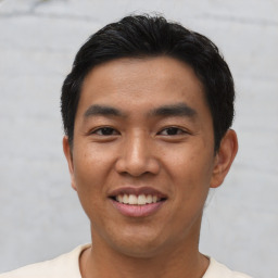 Joyful asian young-adult male with short  black hair and brown eyes