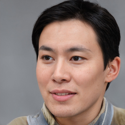 Joyful asian young-adult male with short  brown hair and brown eyes