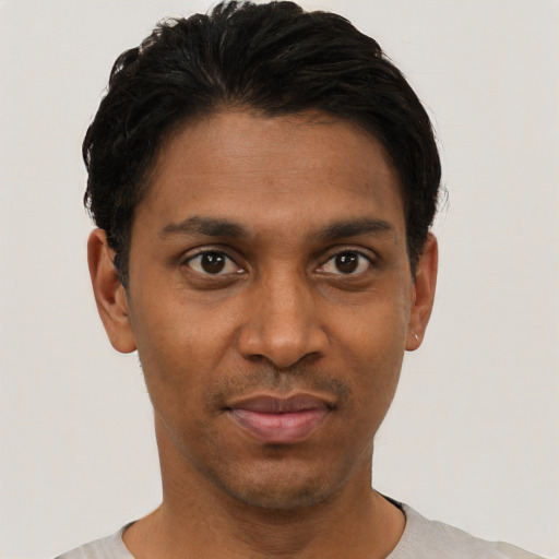 Joyful black young-adult male with short  black hair and brown eyes
