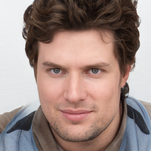 Joyful white young-adult male with short  brown hair and blue eyes