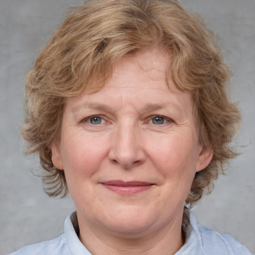 Joyful white adult female with medium  brown hair and blue eyes