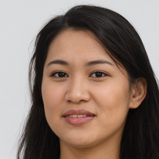Joyful latino young-adult female with long  brown hair and brown eyes