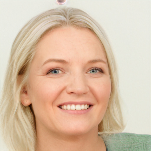 Joyful white adult female with medium  blond hair and blue eyes