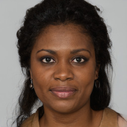 Joyful black young-adult female with long  brown hair and brown eyes