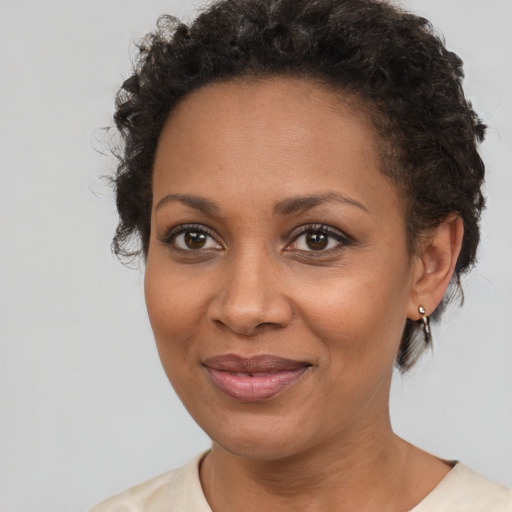 Joyful black adult female with short  brown hair and brown eyes