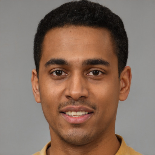 Joyful black young-adult male with short  black hair and brown eyes