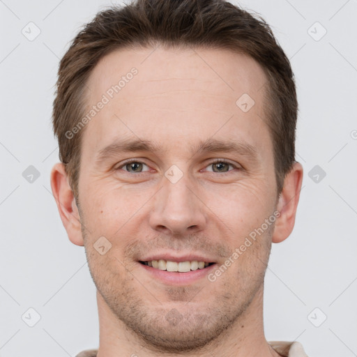 Joyful white young-adult male with short  brown hair and grey eyes