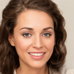 Joyful white young-adult female with long  brown hair and green eyes