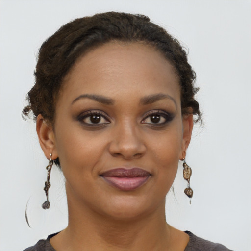 Joyful black young-adult female with short  brown hair and brown eyes