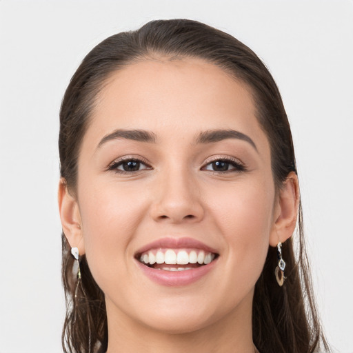 Joyful white young-adult female with long  brown hair and grey eyes