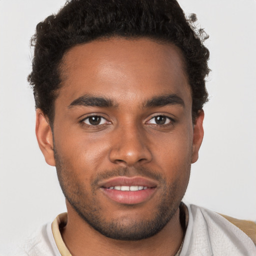 Joyful black young-adult male with short  brown hair and brown eyes