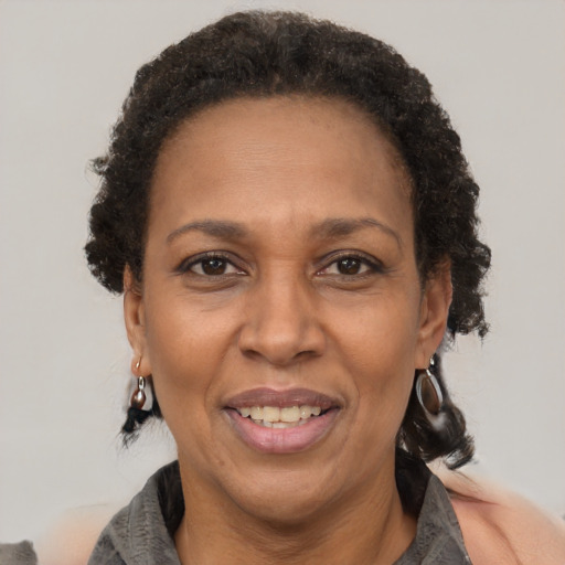 Joyful black adult female with short  brown hair and brown eyes
