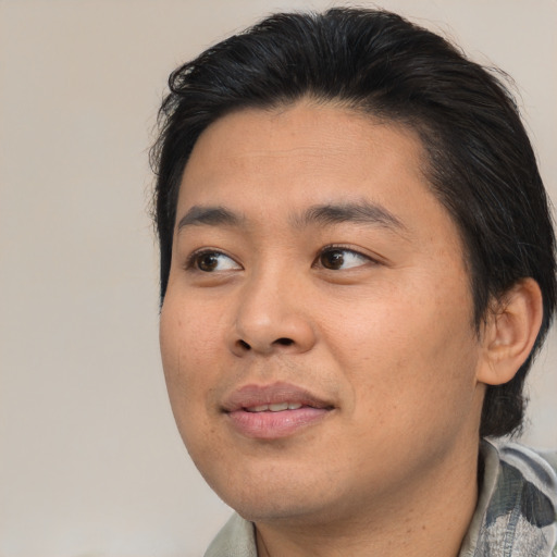 Joyful asian young-adult male with short  brown hair and brown eyes