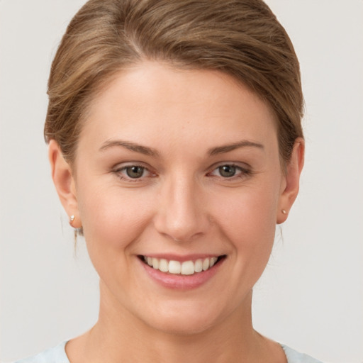 Joyful white young-adult female with short  brown hair and grey eyes