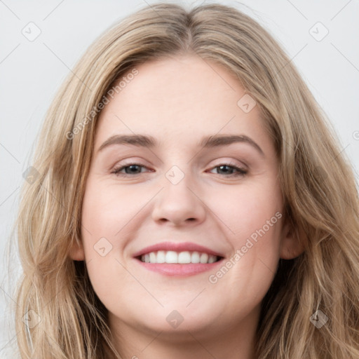 Joyful white young-adult female with long  brown hair and blue eyes