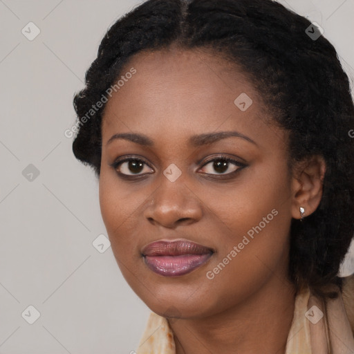 Joyful black young-adult female with long  black hair and brown eyes