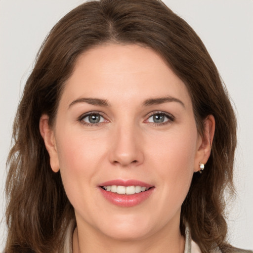 Joyful white young-adult female with long  brown hair and grey eyes