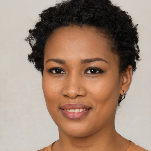 Joyful black young-adult female with short  black hair and brown eyes