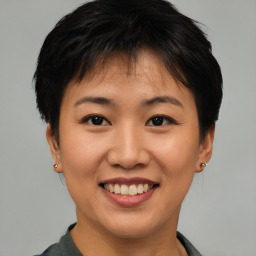 Joyful asian young-adult female with short  brown hair and brown eyes