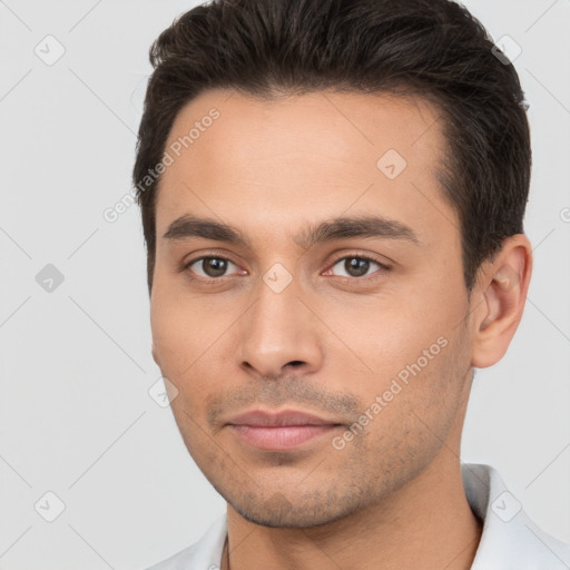 Joyful white young-adult male with short  brown hair and brown eyes