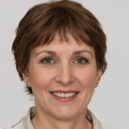 Joyful white adult female with medium  brown hair and grey eyes