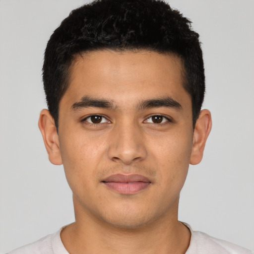 Joyful latino young-adult male with short  black hair and brown eyes