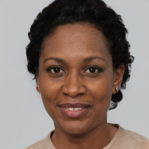 Joyful black adult female with short  black hair and brown eyes