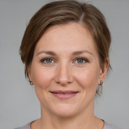 Joyful white adult female with medium  brown hair and grey eyes