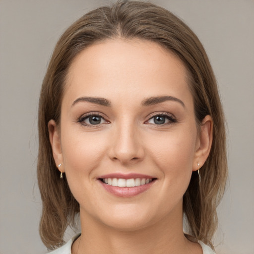 Joyful white young-adult female with medium  brown hair and grey eyes