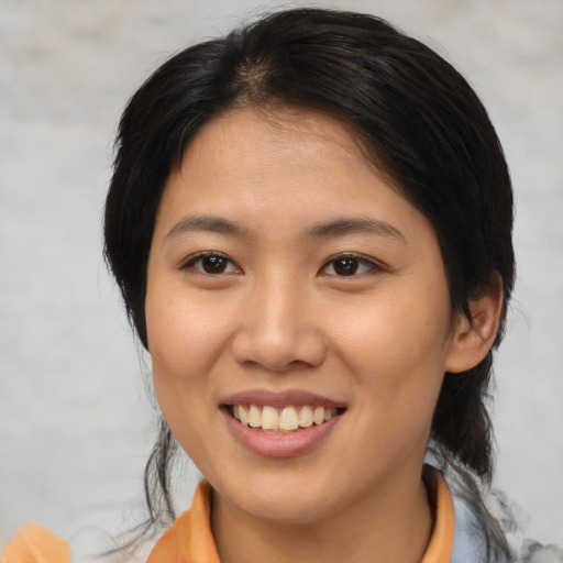 Joyful asian young-adult female with medium  brown hair and brown eyes