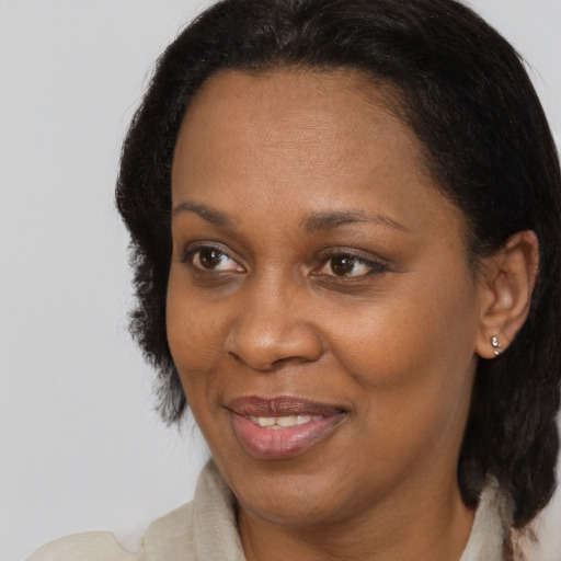 Joyful black adult female with medium  brown hair and brown eyes