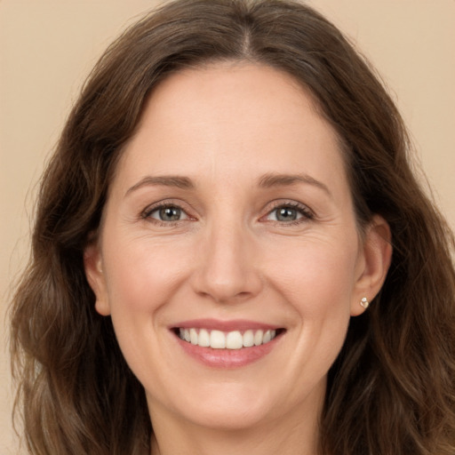 Joyful white young-adult female with long  brown hair and green eyes