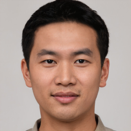 Joyful asian young-adult male with short  black hair and brown eyes