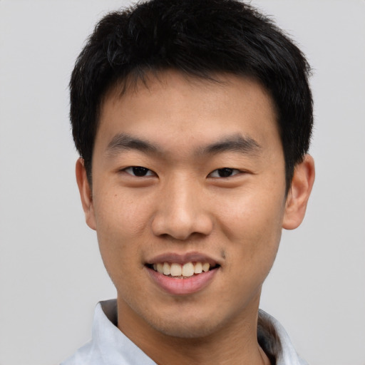 Joyful asian young-adult male with short  black hair and brown eyes