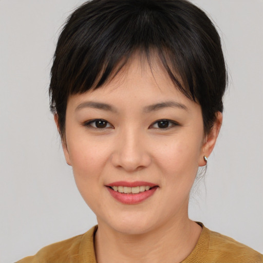 Joyful asian young-adult female with short  brown hair and brown eyes