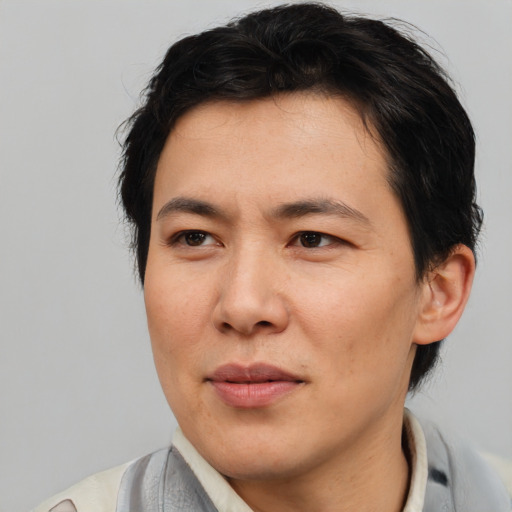 Joyful asian adult male with short  brown hair and brown eyes