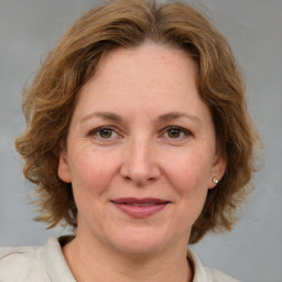 Joyful white adult female with medium  brown hair and blue eyes