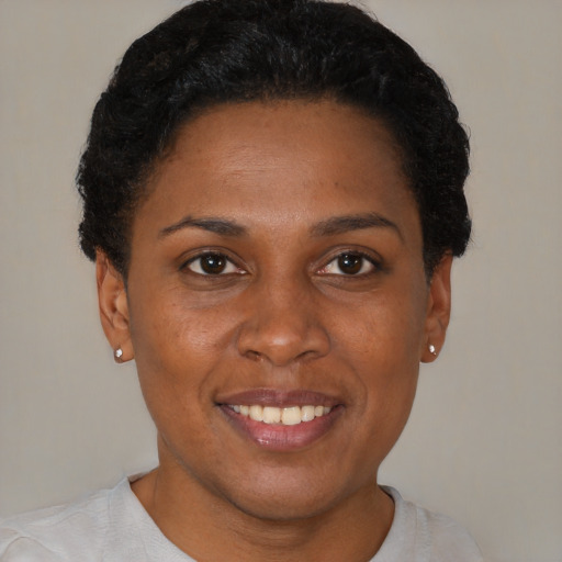Joyful black young-adult female with short  brown hair and brown eyes