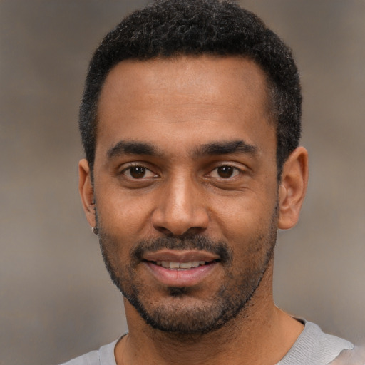 Joyful black young-adult male with short  black hair and brown eyes